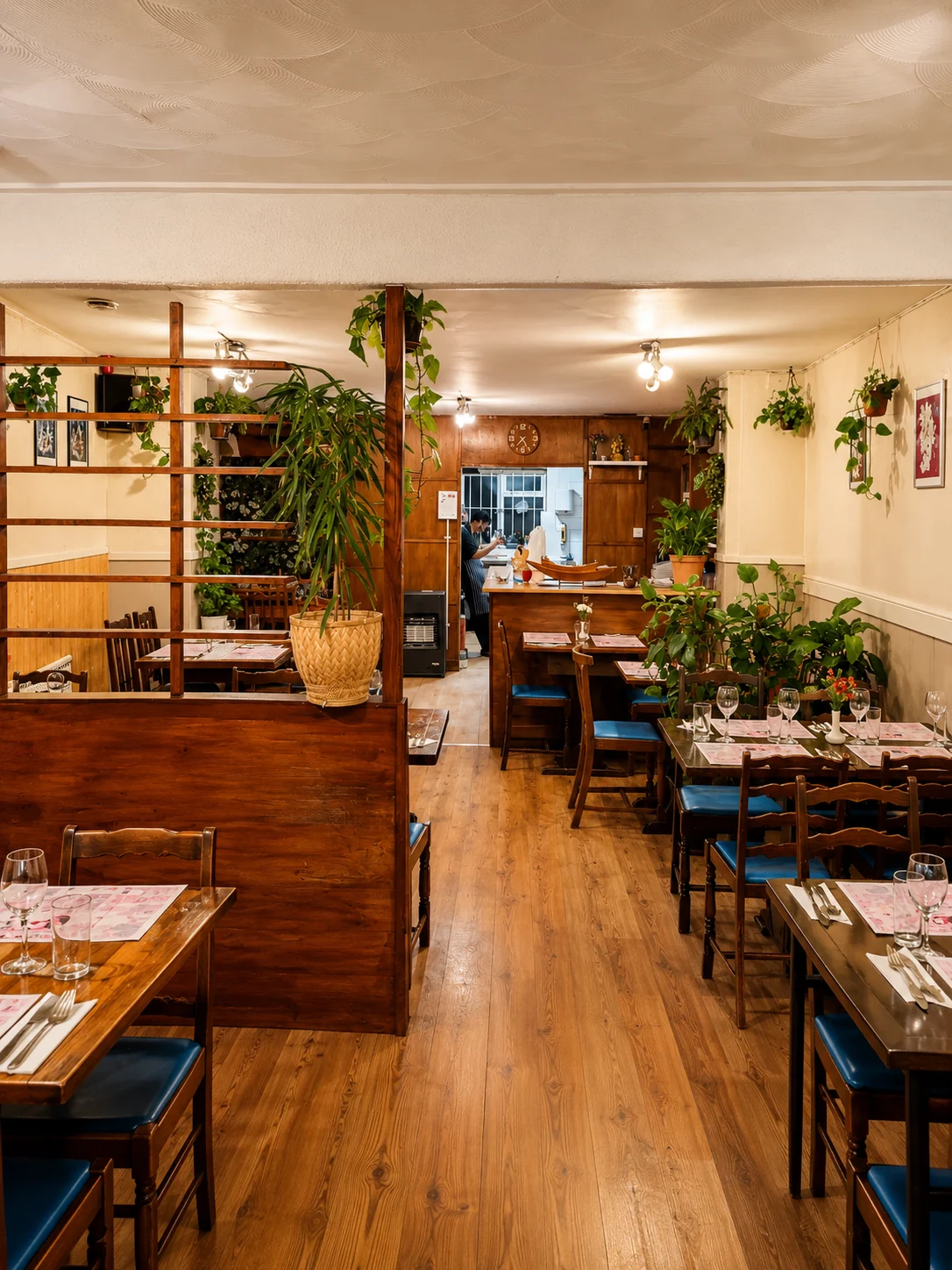 Plant-filled dining room with wooden tables inside Thai Garden